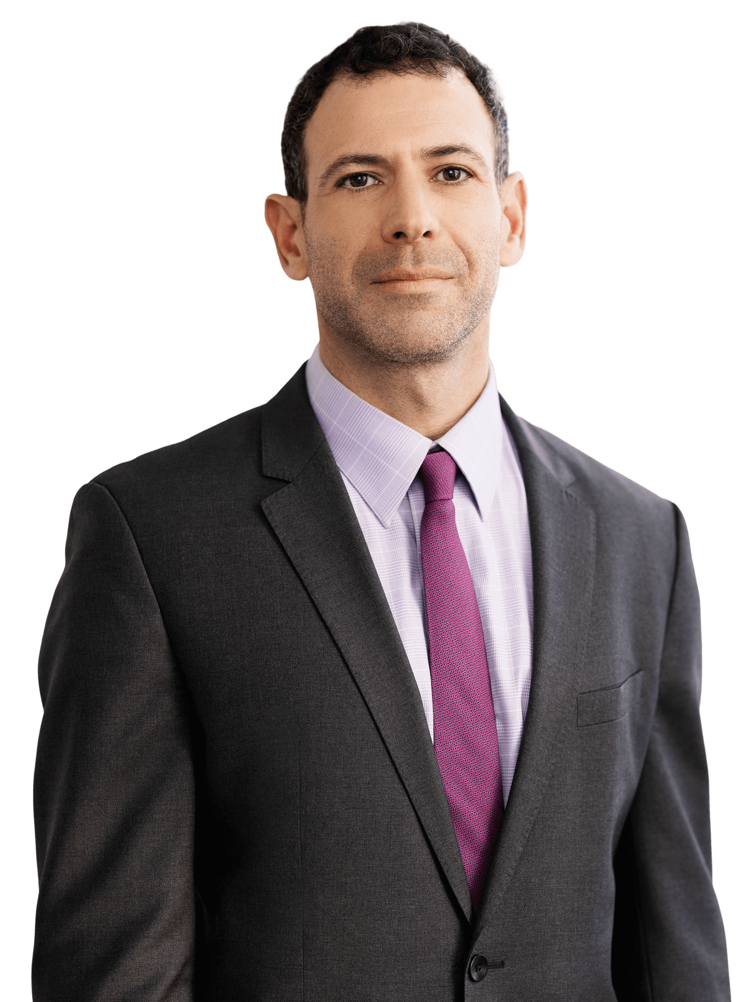 A man in a business suit with a light purple shirt and purple tie stands facing forward with a neutral expression.