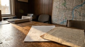Recorded Deed document with embossed seal on wooden office desk beside Philadelphia map