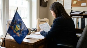 attorney reviewing tax form at desk beside Pennsylvania state flag and QBI Deduction folder